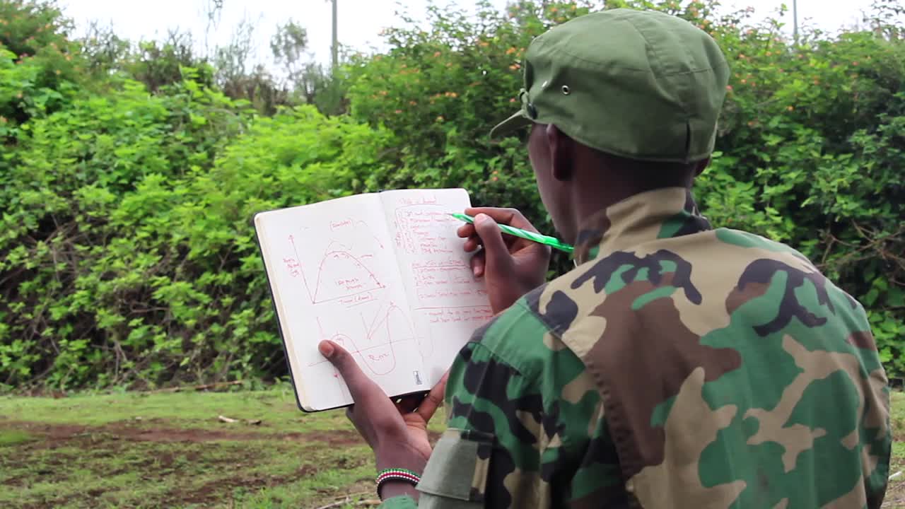Soldato africano che studia il suo taccuino.