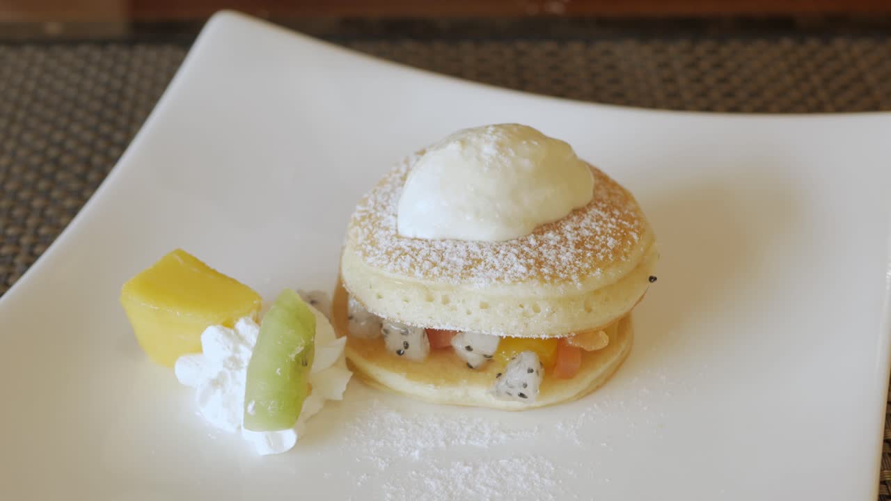 팬케이크에 꿀 시럽을 붓고 포크와 나이프를 사용하여 먹기 좋게 자릅니다.