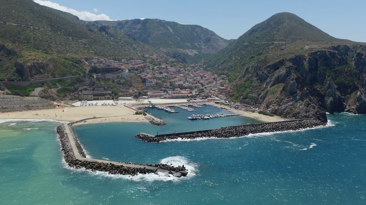 Aerial view of Buggerru Sardegna harbor, vibrant blue sea, rocky coastline