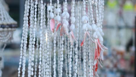 shell wind chimes gently sway in the breeze, creating a serene atmosphere in a phuket market setting