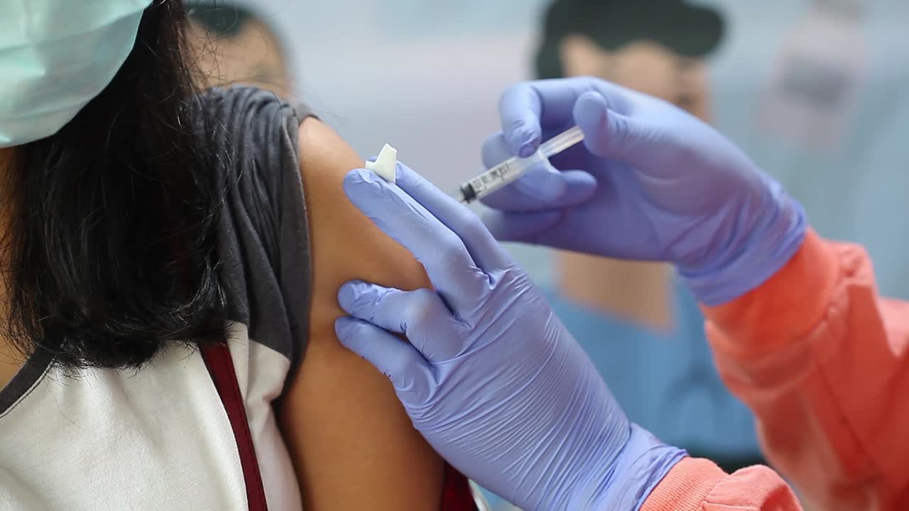video de primer plano del brazo de una mujer al que se le inyecta la vacuna contra el virus de la corona