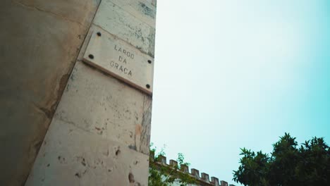 Lisbon-typical-neighborhood-street-name-sign-plate-with-fences-and-trees