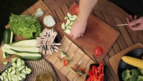 top-down shot of a young man preparing vegetable skewers medium shot