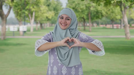 Happy-Muslim-woman-showing-heart-sign-in-park