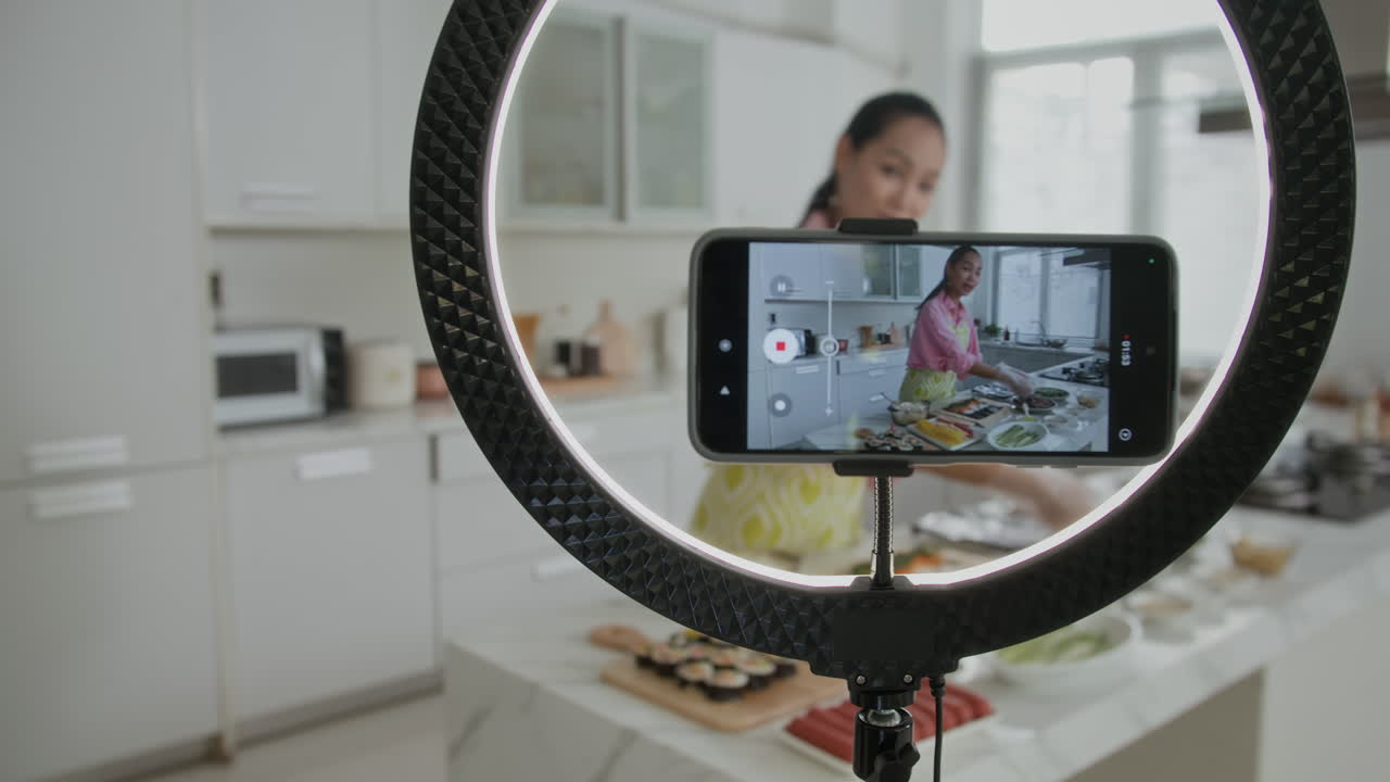 Blogger donna che filma su smartphone mentre cucina il kimbap