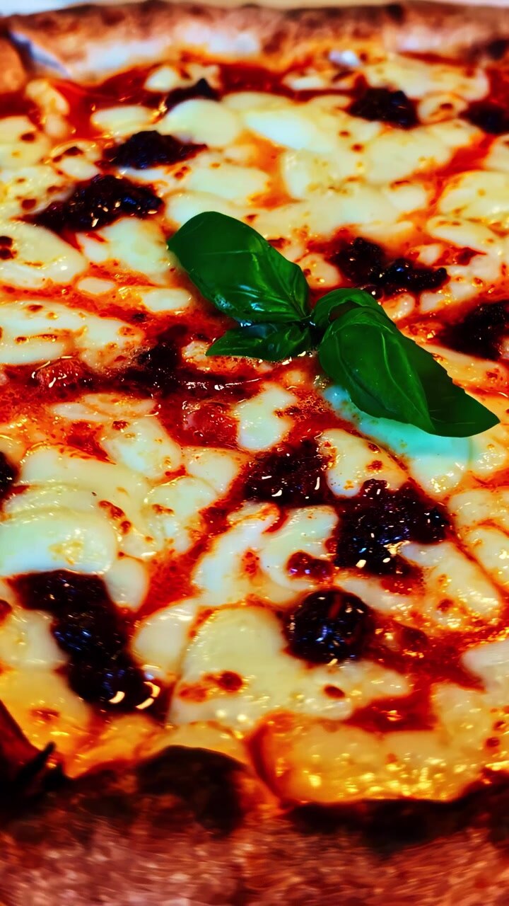 Una deliziosa pizza Margherita condita con formaggio fuso, salsa di pomodoro e foglie di basilico fresco. Ideale per blog di cucina o promozioni culinarie