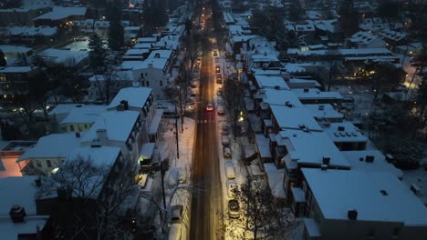 snowy evening in a residential neighborhood with glowing streetlights and snow-covered roofs, creating a serene winter scene