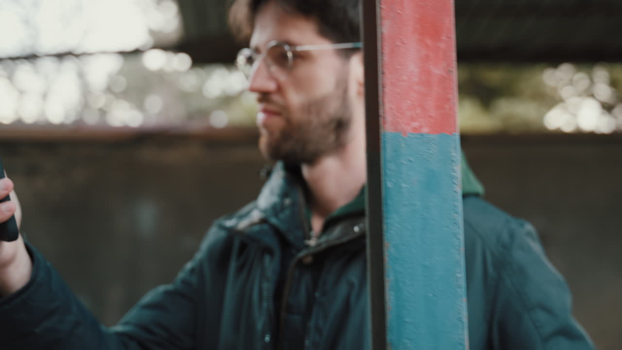 Muž zkouší nejlepší pózu pro selfie fotografie se svým chytrým telefonem.