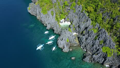 Aerial-view-of-the-Secret-Beach,-Shallow-tropical-lagoon-hidden-surrounded-by-giant-karst-rocks