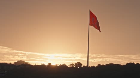 massive turkish flag waves against vivid orange sunset sky, istanbul, slomo