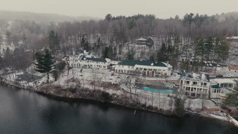 snow falling on manoir hovey hotel during winter by the lake massawippi in quebec, canada