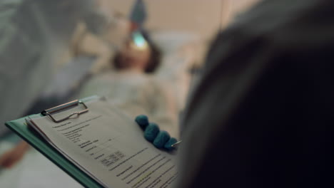 doctor holding medical clipboard make note closeup. hospital intensive care unit