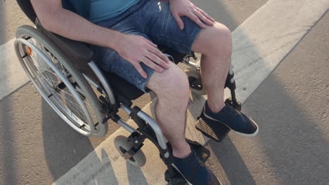 desability man on wheel chair on pedestrian crossing. close up.