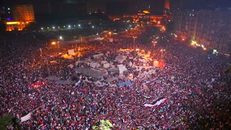 fireworks go off above protestors gathered in tahrir square in cairo egypt at a large nighttime rally 3