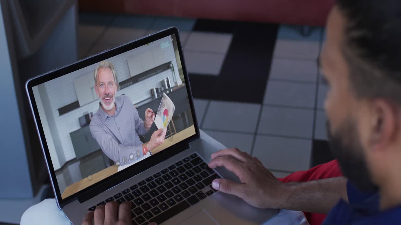 hombre de oriente medio teniendo una videollamada con un colega masculino en una computadora portátil