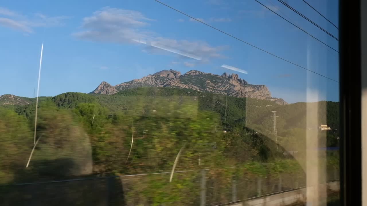 Scenic 4K view of Montserrat filmed from a moving train. A cinematic blend of speed, nature, and reflection creates a peaceful and immersive window-side travel experience