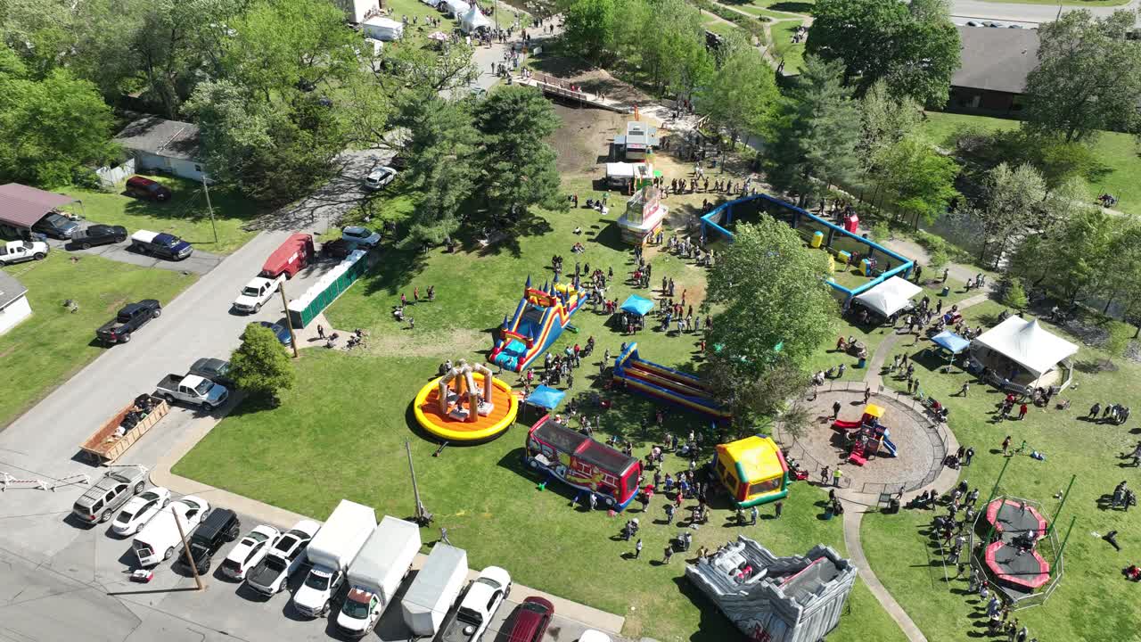 Hyperlapse aerial orbit of Dogwood Festival kids park bounce castle and attractions, Siloam Springs, Arkansas