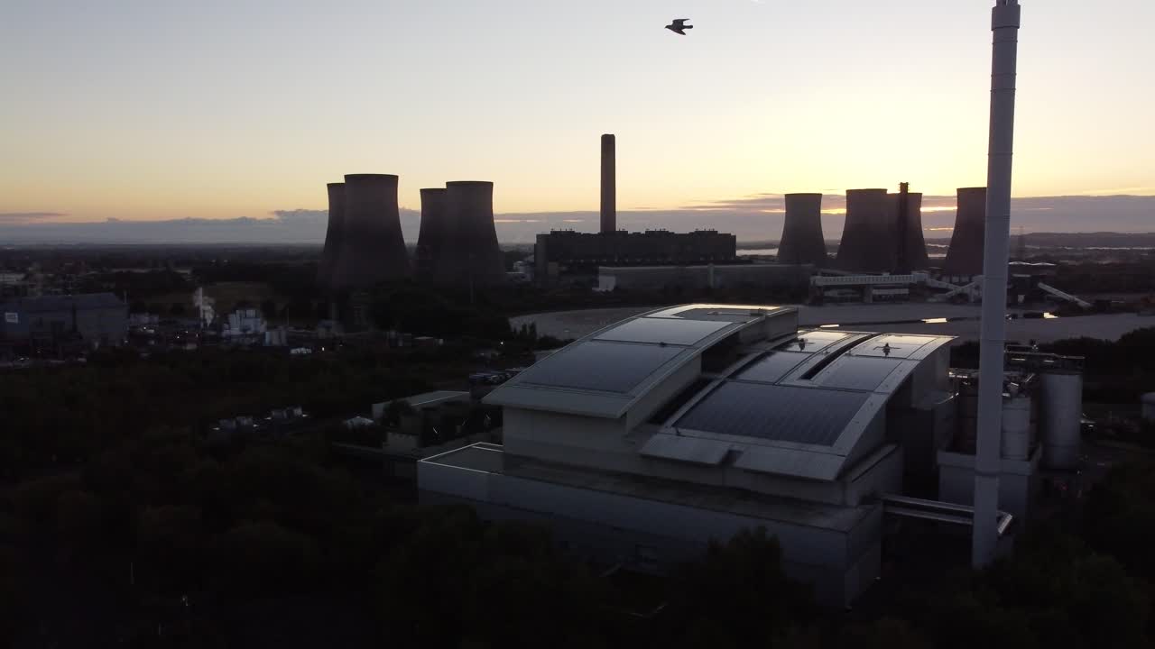 현대 영국 태양광 옥상 공장과 화석 연료 발전소 스카이라인을 선회하는 일출 조감도