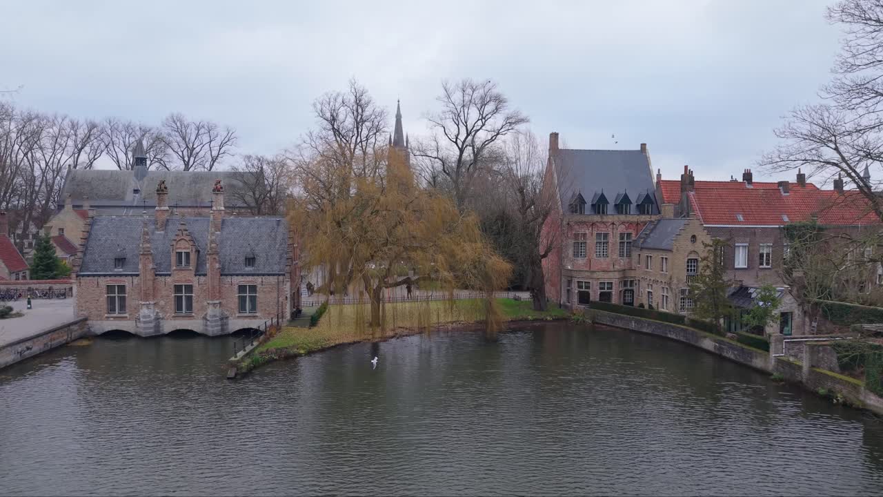 Et udzoomende skud, der fanger bygninger langs Kærlighedssøen i Brugge, afslører det historiske Sashuis og charmerende kanalarkitektur.