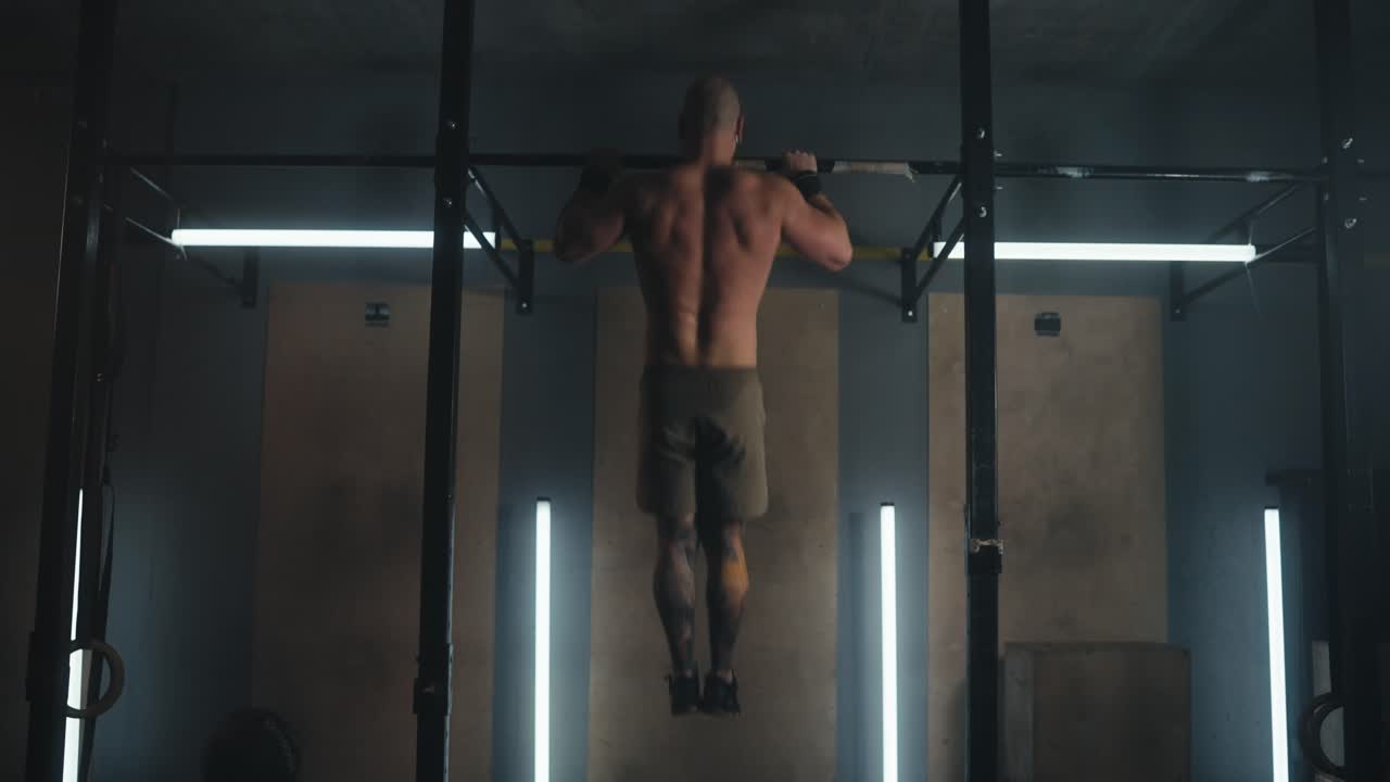 hombre realizando pull-ups en el gimnasio