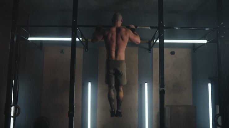 Man Performing Pull-Ups in Gym