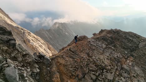 excursionista masculino caminando por un sendero alpino en los alpes italianos y desapareciendo en la niebla