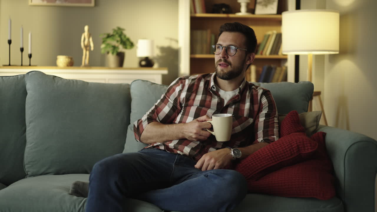 Man Relaxing on Sofa with Coffee