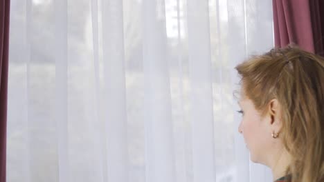 Mujer-Madura-Pensativa-Mirando-Por-La-Ventana-Desde-Casa.