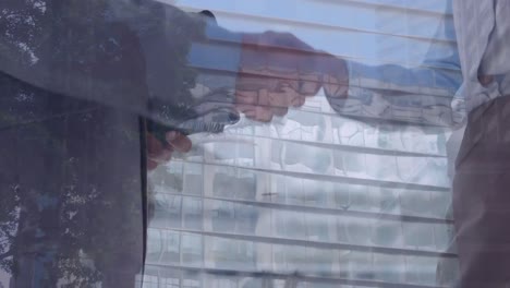 animation of businessman handshake over cityscape