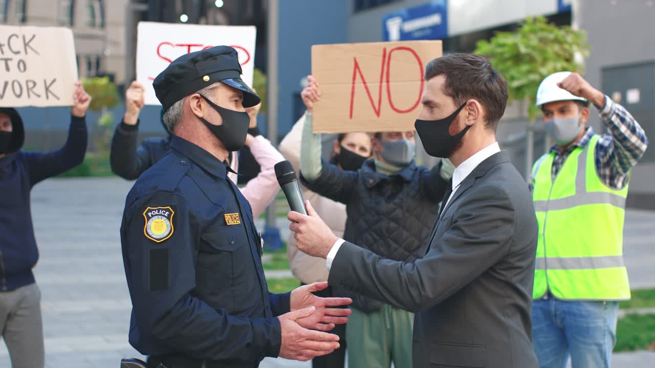 코비드 19에 항의하는 경찰관과의 인터뷰에서 보호 마스크를 쓴 백인 언론인이나 특파원