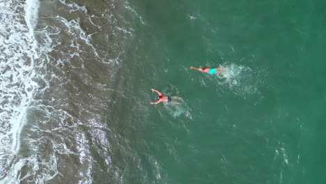 personas nadando en agua turquesa en la playa