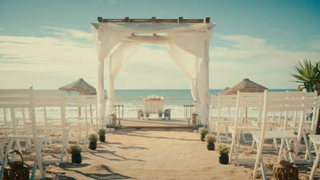 vacío decorado al aire libre lugar de la boda con sillas para la ceremonia oficial en una playa cerca del mar o el océano. todo preparado para hermosas celebraciones de matrimonio romántico. zoom out tiro.
