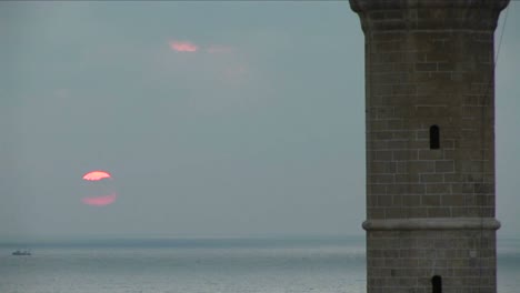 el sol se hunde detrás del minarete de una mezquita en israel