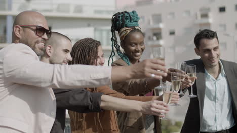 side view of happy employees clinking glasses of champagne