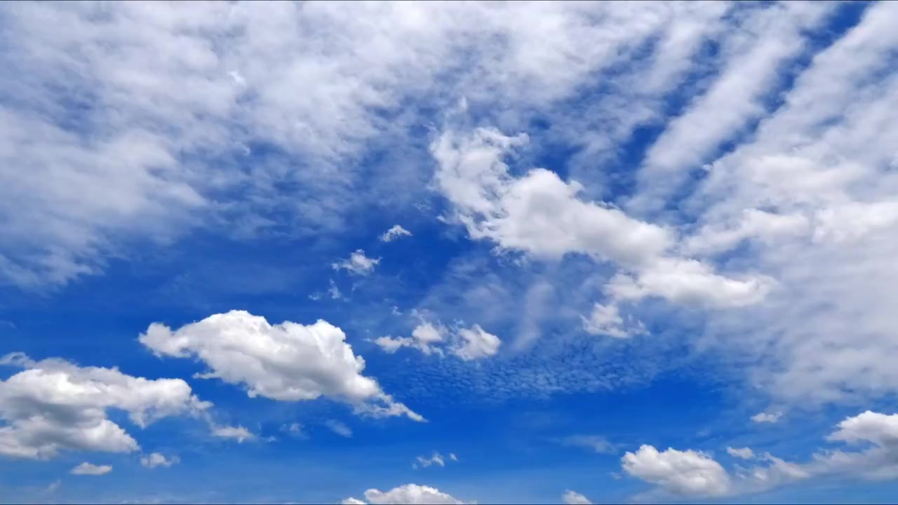 Timelapse di nuvole cumulo bianche che si muovono in un cielo azzurro brillante, catturando il movimento naturale del tempo e un paesaggio atmosferico sereno.