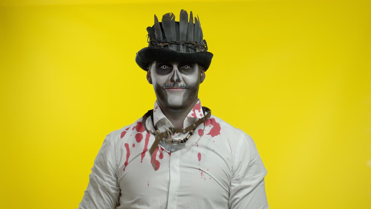 hombre siniestro con maquillaje de cráneo haciendo caras y mostrando el dedo medio. mal comportamiento gesto. halloween