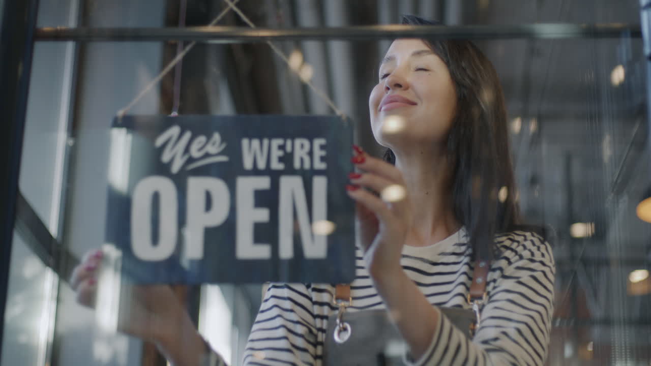 Business owner hanging open/closed sign