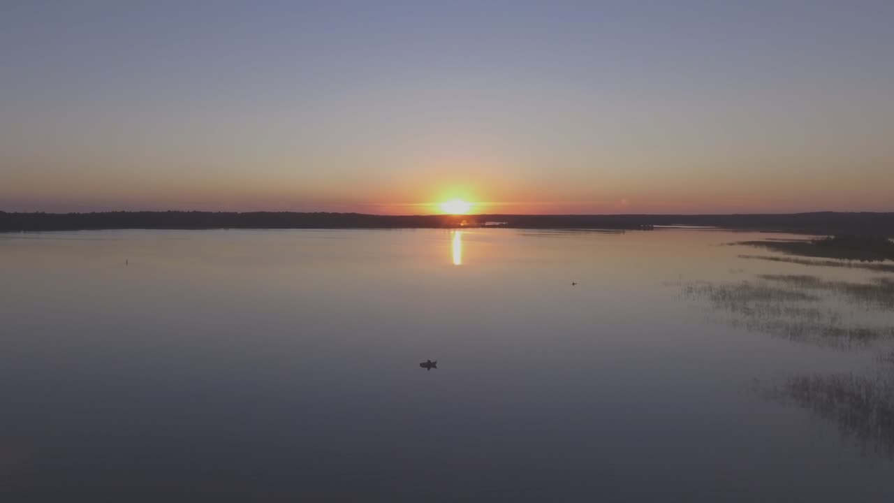 pescador en un bote en un lago en una tranquila tarde de verano al atardecer