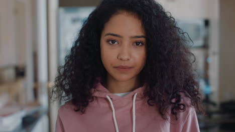 portrait beautiful teenage girl in kitchen at home looking serious expression