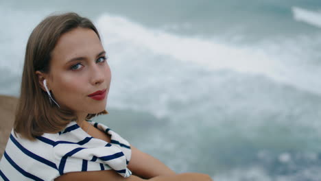 Smiling-millennial-listening-music-at-ocean-coast-closeup.-Happy-girl-chill