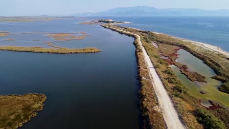 vista aérea de la carretera entre la impresionante costa y la laguna natural con piscifactorías