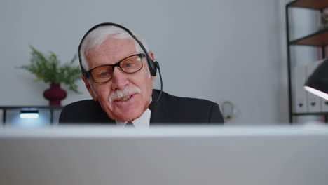 Senior-old-businessman-wearing-headset-working-in-office,-call-center,-conference,-support-agent