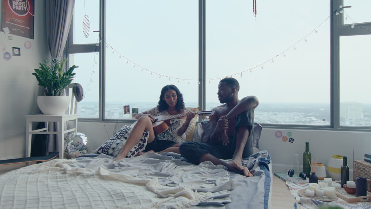 Romantic Couple Singing and Playing the Guitar in Bedroom