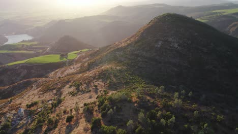 Aerial-of-rolling-hills-and-sunbeams-hitting-vibrant-vineyards-in-the-Napa-Valley