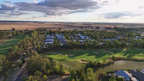 Am-Späten-Nachmittag-Luftaufnahme-über-Dem-Golfplatz-Black-Bull-Und-Neuen-Häusern-Mit-Weizenfeldern-Dahinter