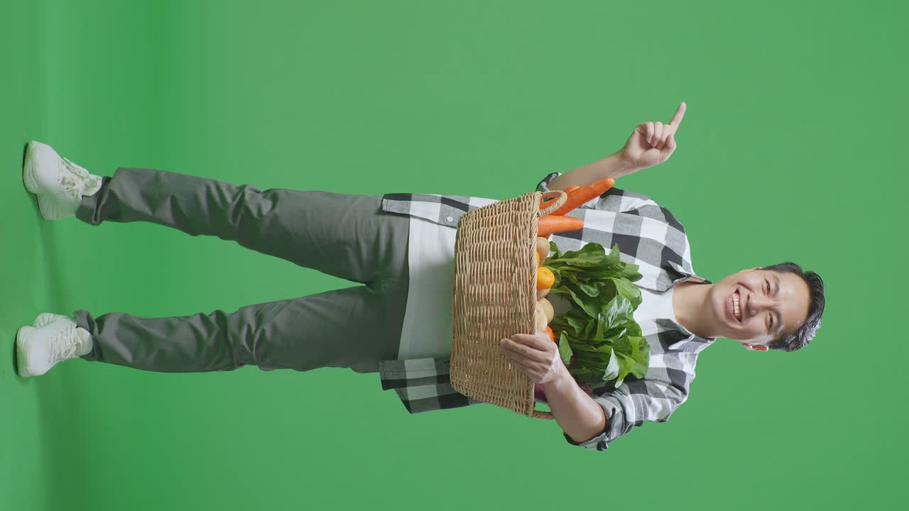 hombre sosteniendo una canasta de verduras en la pantalla verde