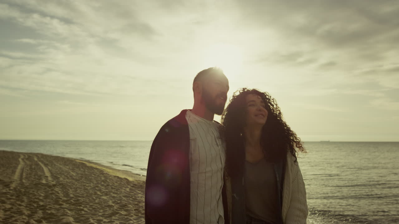 persone romantiche che amano il mare, il paesaggio della spiaggia, la coppia che guarda il tramonto, l'acqua, la natura.