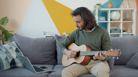 man learning guitar at home