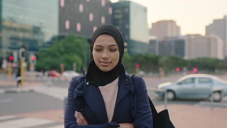 portrait of young muslim business woman executive looking pensive at camera standing arms crossed on sidewalk street urban city background