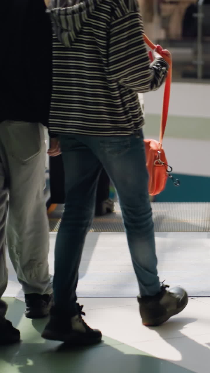 A bustling mall scene with people moving about and some going down the escalator. this video highlights the dynamic environment and activity within the mall